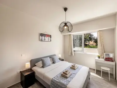a white bedroom with a bed and a window at Mythical Blue Apartment 004 in Protaras