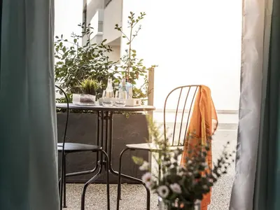 a table with plants and a chair in a room at Mythical Blue Apartment 004 in Protaras