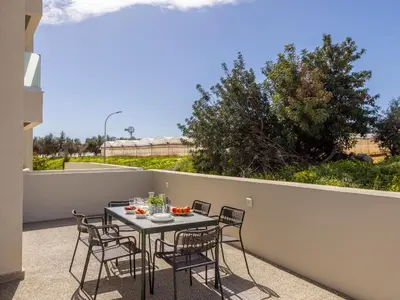 a patio with a table and chairs on a balcony at Mythical Blue Apartment 004 in Protaras