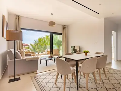 a living room with a dining room table and chairs at Sanders Breeze Limassol in Limassol