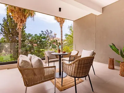 a patio with chairs and a table in front of a window at Sanders Breeze Limassol in Limassol