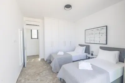 a hotel room with two beds and a table at Aqua Pearl Villas in Protaras