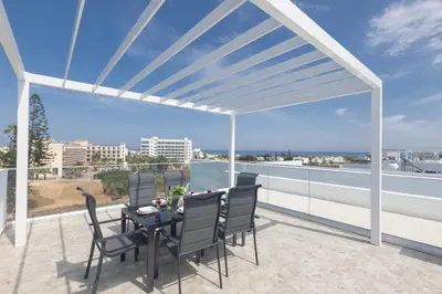 a patio with a table and chairs on a balcony at Aqua Pearl Villas in Protaras