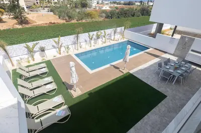 an overhead view of a swimming pool with chairs and a table at Aqua Pearl Villas in Protaras