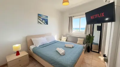 a bedroom with a bed with two towels on it at Kolonaki Seaview 1BDR Finikoudes in Larnaka