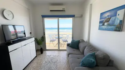 a living room with a couch and a view of the ocean at Kolonaki Seaview 1BDR Finikoudes in Larnaka
