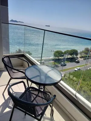 a table and chairs on a balcony with a view of the ocean at Seafront City Center Studio in Limassol