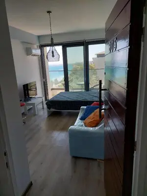 a bedroom with a bed and a couch in a room with windows at Seafront City Center Studio in Limassol
