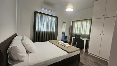 a bedroom with a white bed and a desk and window at STAY Limdream Apartment in Limassol
