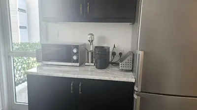 a kitchen counter with a microwave and a refrigerator at STAY Limdream Apartment in Limassol