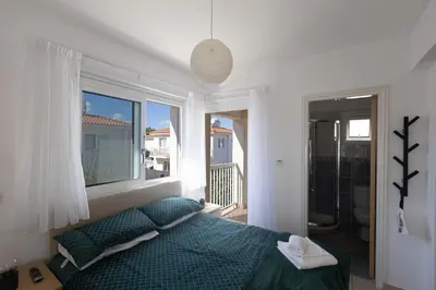 a bedroom with a green bed and a large window at Protaras Blue River Villa BR26 in Protaras