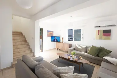 a living room with a couch and a table at Protaras Blue River Villa BR26 in Protaras