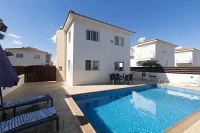 a swimming pool in front of a house at Protaras Blue River Villa BR26 in Protaras