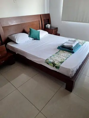 a bed with white sheets and green pillows on it at D Pitsillos Homes in Larnaka