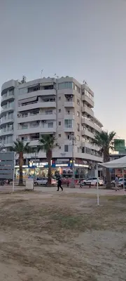 a large building with a person walking in front of it at D Pitsillos Homes in Larnaka