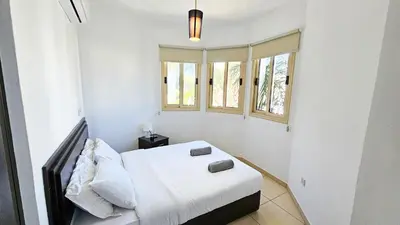 a white room with a bed and two windows at Palmvibes Villa With Private Pool in Paralimni