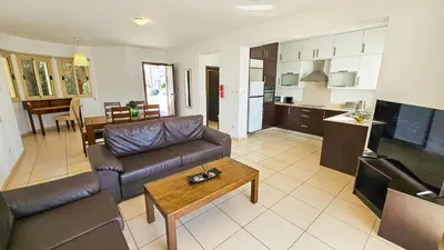 a living room with a couch and a table at Palmvibes Villa With Private Pool in Paralimni