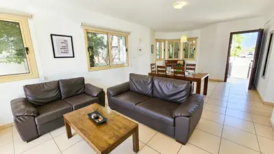 a living room with two leather couches and a table at Palmvibes Villa With Private Pool in Paralimni