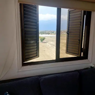 a window with a view of the beach from a couch at Danit apartmnt by the sea in Zygi