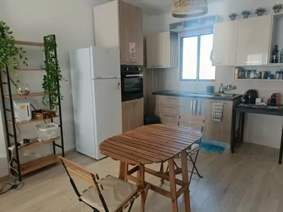 a kitchen with a wooden table and a white refrigerator at Danit apartmnt by the sea in Zygi