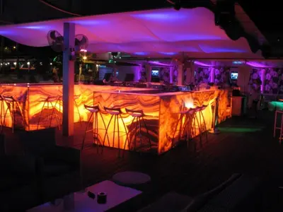 a bar in a restaurant with purple lights at Vrissiana Boutique Beach Hotel in Protaras
