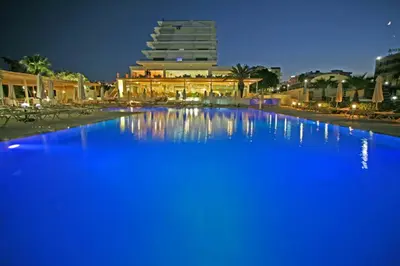 a large pool of blue water in front of a building at Vrissiana Boutique Beach Hotel in Protaras