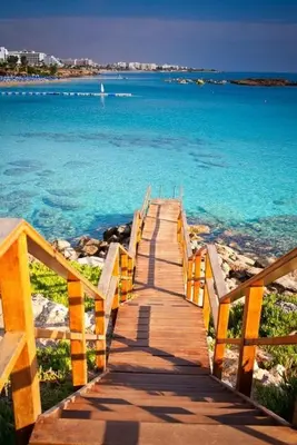 a wooden boardwalk leading to the ocean on a beach at Odessa Beach Hotel in Protaras