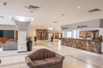 a lobby of a hospital with a chair and a counter at Antigoni Hotel in Protaras