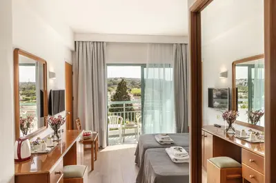 a hotel room with a bed and a balcony at Antigoni Hotel in Protaras