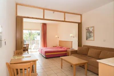 a living room with a couch and a bed at Tsokkos Paradise Holiday Village in Ayia Napa