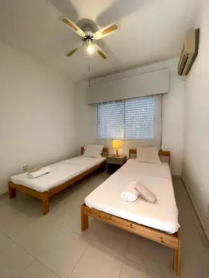 two beds in a room with a ceiling fan at Central Comfort in Nicosia - Orfeos By Platform 357 in Nicosia
