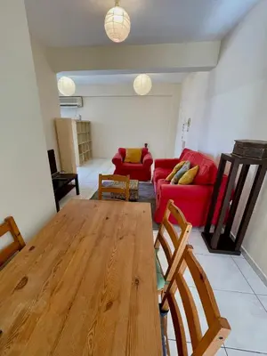 a living room with a table and a red couch at Central Comfort in Nicosia - Orfeos By Platform 357 in Nicosia