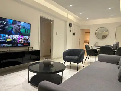 a living room with a couch and chairs and a flat screen tv at Melia Suites in Limassol