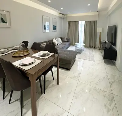a living room with a table and a couch at Melia Suites in Limassol