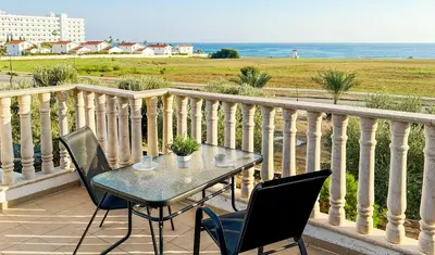 a table and chairs on a balcony with the ocean at Beachfront Villa with Private Pool and Exotic Fruit Garden in Pyla