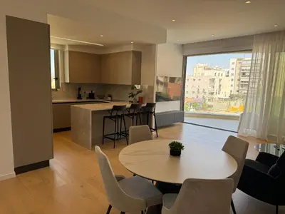 a kitchen and living room with a table and chairs at WealthyStays Parkside Residence in Nicosia
