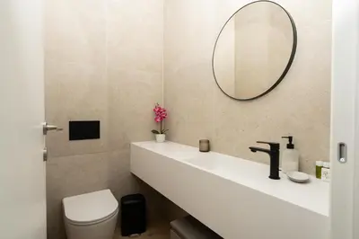 a bathroom with a white sink and a mirror at WealthyStays Parkside Residence in Nicosia