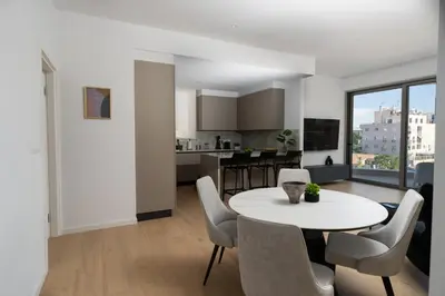 a kitchen and living room with a table and chairs at WealthyStays Parkside Residence in Nicosia