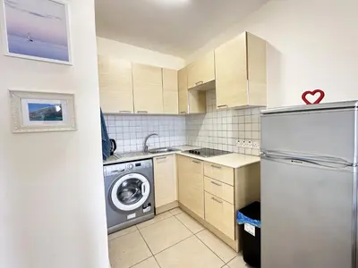 a kitchen with a refrigerator and a dishwasher at Angela's Sunset Holiday Apt - Ayia Napa in Ayia Napa