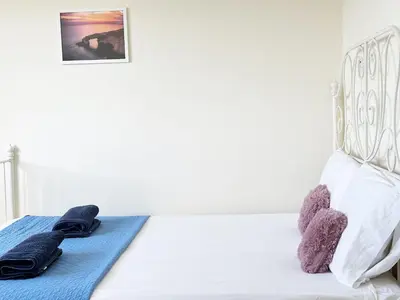 a white bed with two towels on top of it at Angela's Sunset Holiday Apt - Ayia Napa in Ayia Napa