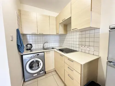 a small kitchen with a washing machine in it at Angela's Sunset Holiday Apt - Ayia Napa in Ayia Napa
