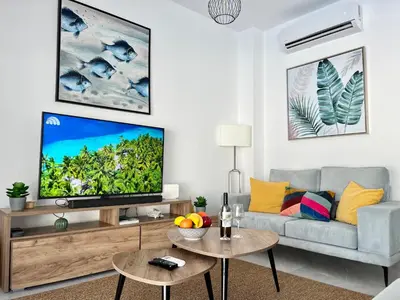 a living room with a gray couch and a flat screen tv at STAY Villa Palm in Protaras