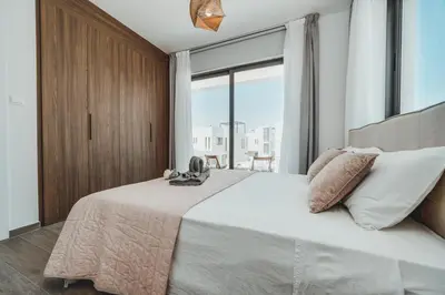 a bedroom with a large bed with a large window at STAY Villa Palm in Protaras