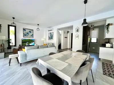 a dining room and living room with a table and chairs at STAY Villa Palm in Protaras