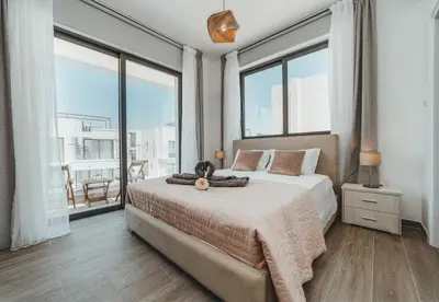 a bedroom with a large bed and large windows at STAY Villa Palm in Protaras