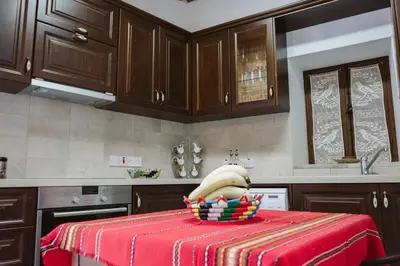 a kitchen with a table with a bowl of fruit at Ariadni Cottage in Vasa