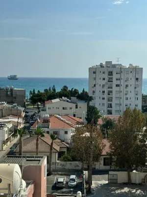 a view of a city with a large building and the ocean at The Palm Suites - Adults Only in Limassol