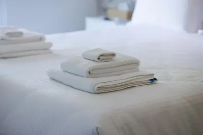 a pile of towels sitting on top of a bed at The Palm Suites - Adults Only in Limassol