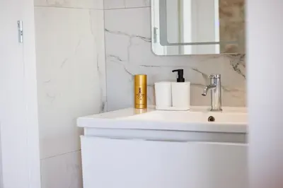 a bathroom with a sink and a mirror at The Palm Suites - Adults Only in Limassol