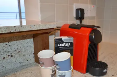 a coffee maker and cups on a counter at Awesome Sea & Marina View City Center 1 Bdr Flat in Larnaka